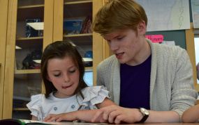 Man and girl reading from a book