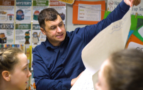 Teacher showing presentation to two children