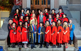 MIC PhD graduates standing on college steps