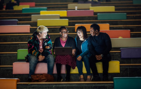 Four students sitting on couches in a college recreational area