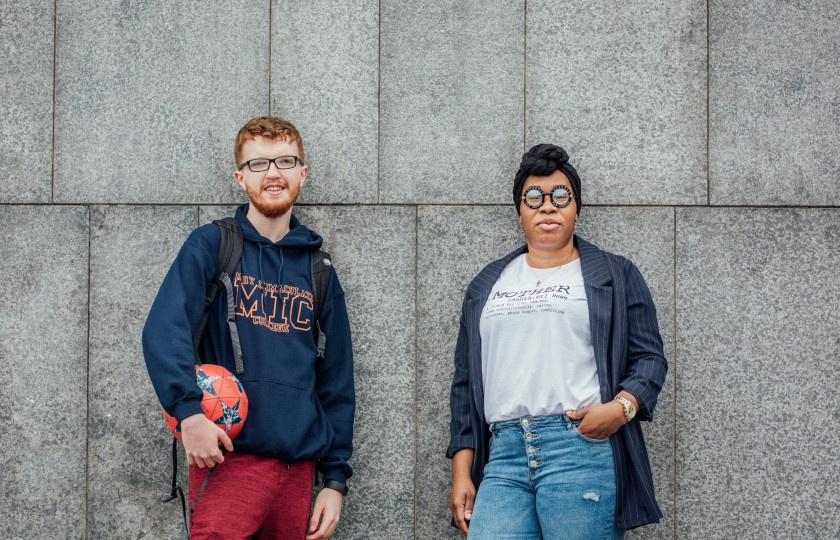 A male and female student standing outside an MIC building