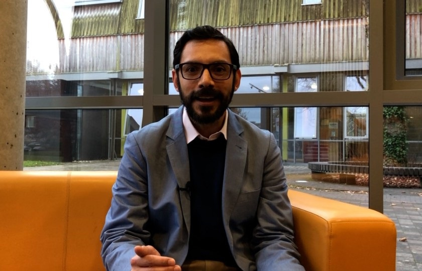 Dr Daniel Vázquez sitting on campus 