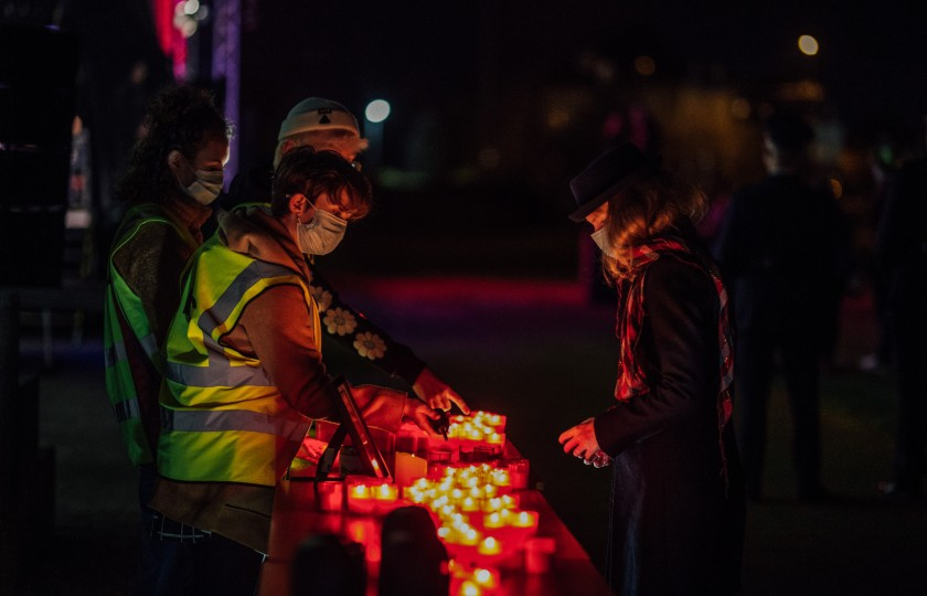 Marshals hand candle to a member of the crowd