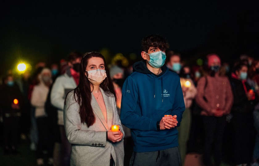 A female and male holding candles