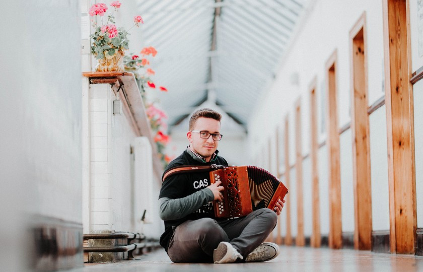 Student with accordion sitting in corridor