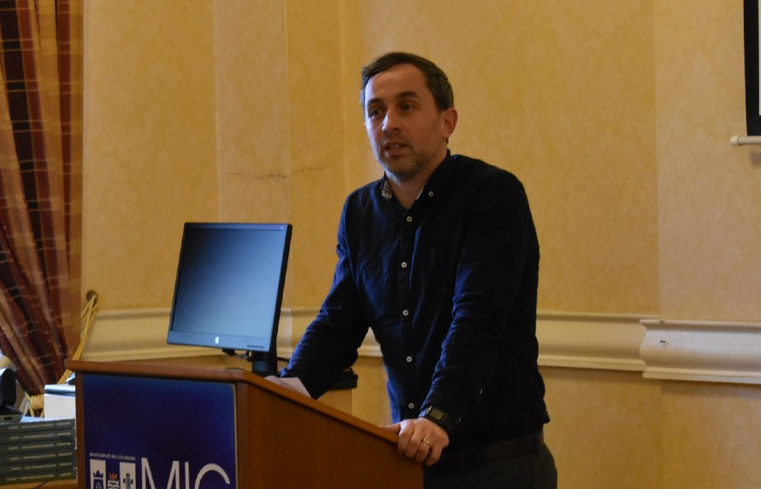 Dr Brian Hughes speaking at a lecture stand