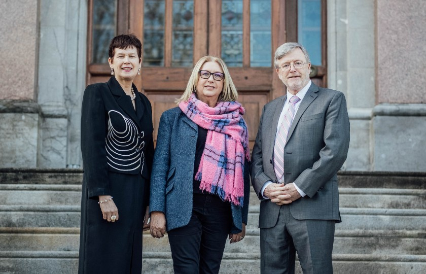 Mary McAleese standing with Trish Kieran to her left and Eugene Wall to her right