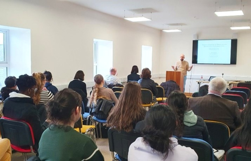 Dr Genco Guralp (UL) addressing an audience of staff and students during his invited lecture