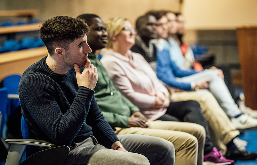 Postgraduate students sitting in a lecture theatre listening to the speaker