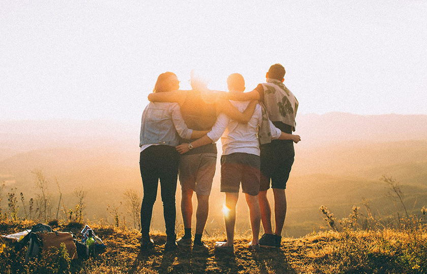 Four friends on a hill at sunset