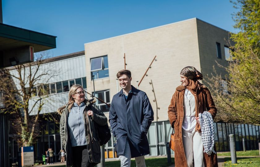 Three postgraduate students walking on MIC campus