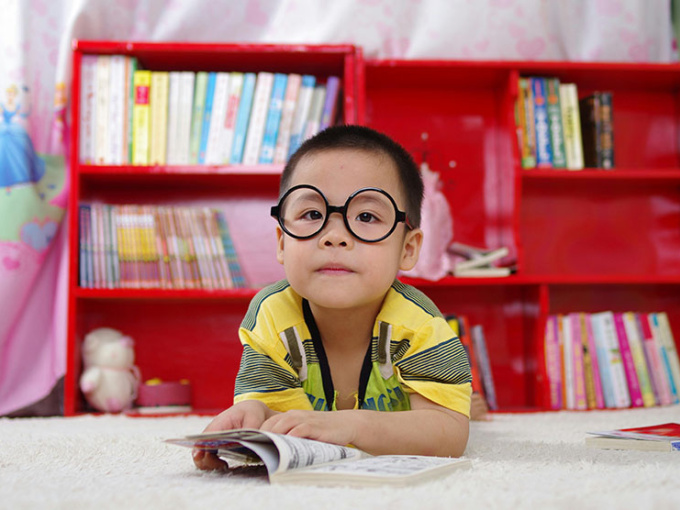 Boy in a bedroom with open book