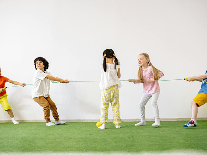 Five children playing tug of war