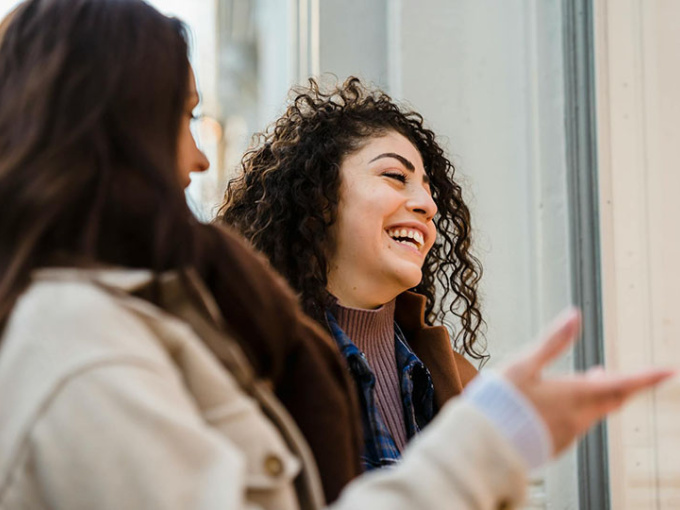 Two women in conversation, laughing